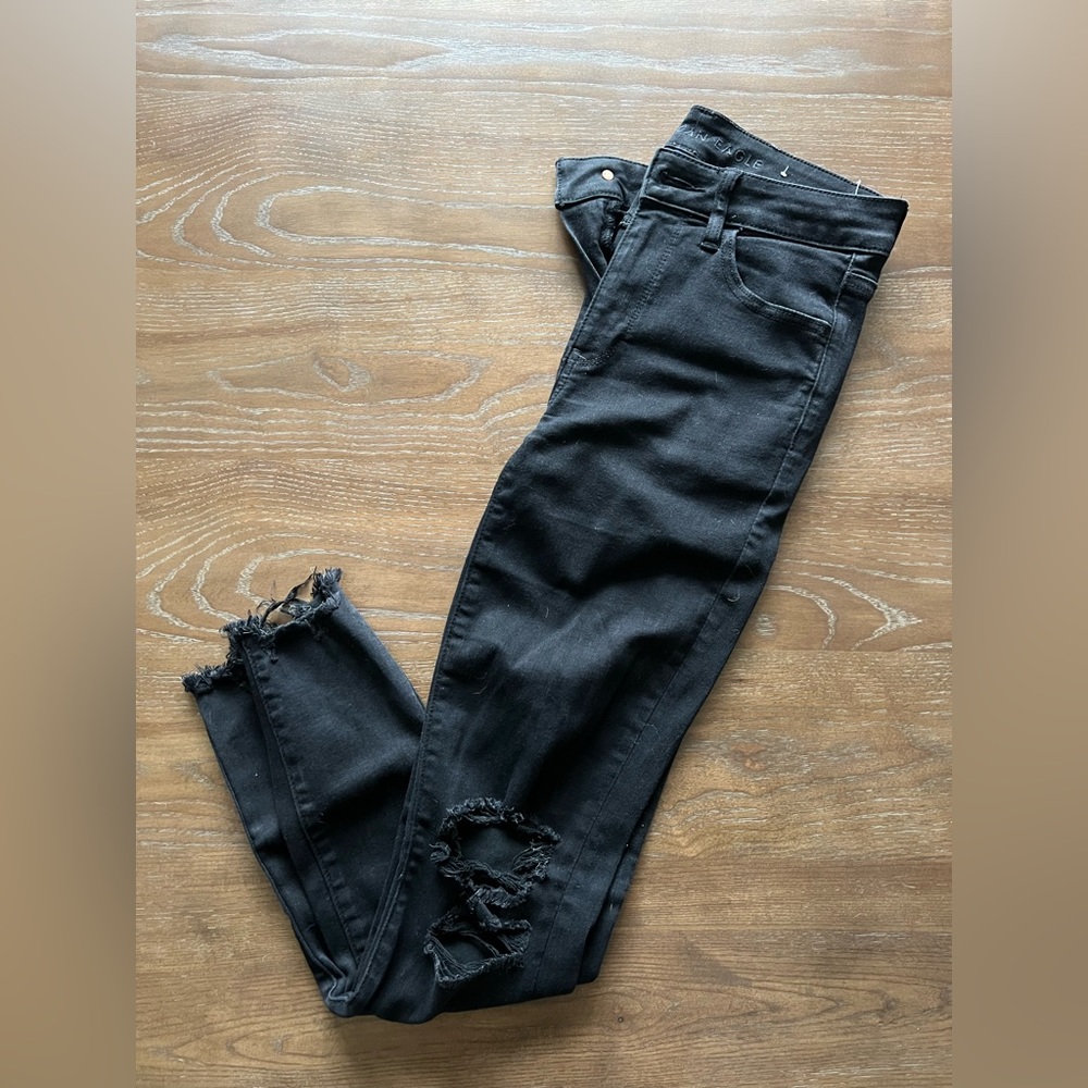 Distressed black jeans with raw hem
